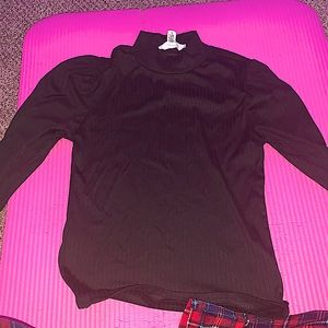A black, turtle ish neck, long sleeved with Puffed shoulders